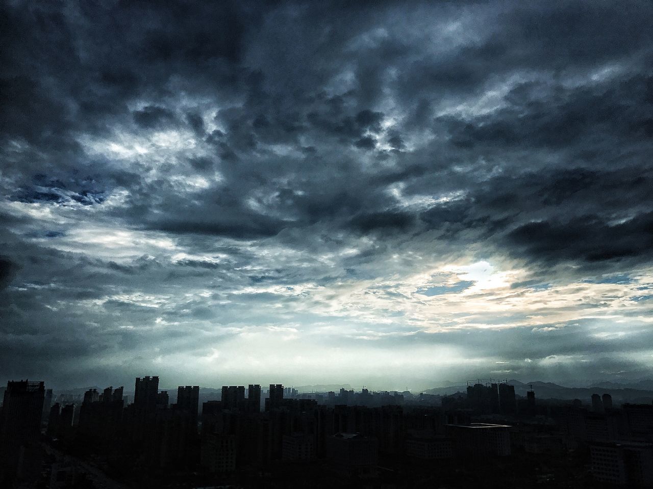 cloud - sky, sky, cityscape, building exterior, city, architecture, atmospheric mood, no people, skyscraper, dramatic sky, built structure, storm cloud, weather, silhouette, nature, outdoors, beauty in nature, sunset, day, modern, urban skyline