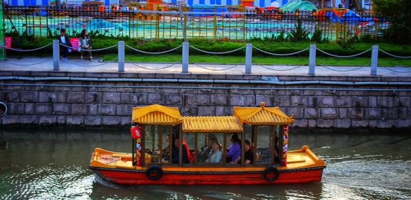 Boats sailing in river against buildings