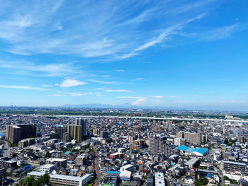 High angle view of buildings in city against blue sky