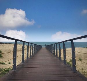 Wooden pier over sea against sky