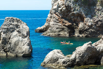 High angle view of tourist kayaking on adriatic sea amidst rocks