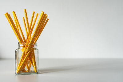 Close-up of glass jar on table against white background