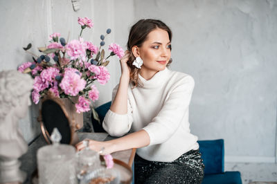 Portrait of young woman holding bouquet