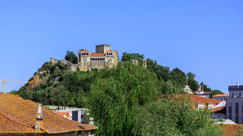 Houses in town against clear blue sky