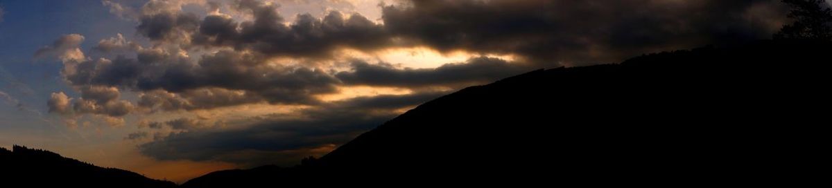 Silhouette of mountain against cloudy sky