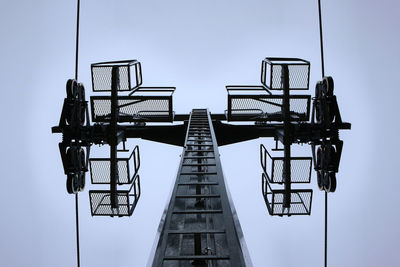 Low angle view of ski-lift against sky