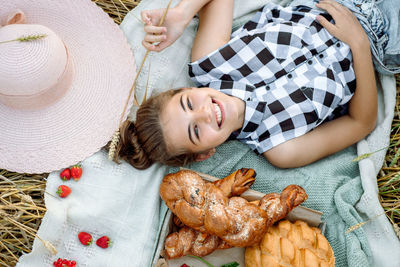 High angle view of teenage girl lying at farm with food
