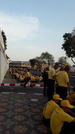 People on street against sky in city