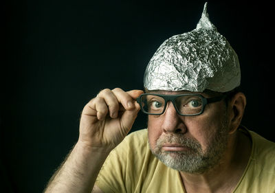 Close-up portrait of man against black background