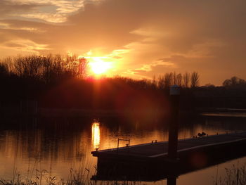 Scenic view of lake against orange sky