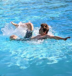 Teenage boy having fun swimming in pool