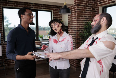 Portrait of smiling friends standing in office