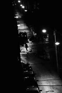 Man walking on illuminated street at night