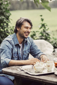 Happy mid adult man having breakfast at organic farm