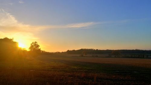 Scenic view of field against sky during sunset