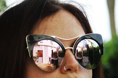 High section of woman wearing sunglasses with reflection