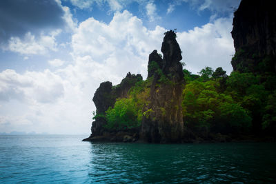 Rock formations by sea against sky