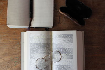 Directly above shot of books with eyeglasses on table