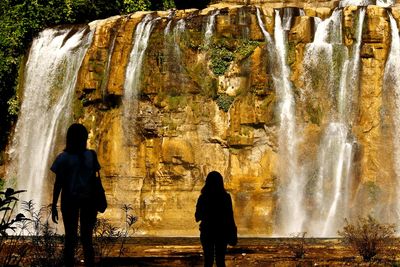 Silhouette women standing at tinuy-an falls
