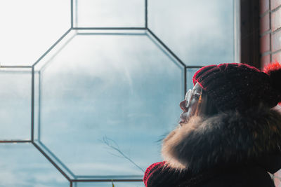 Woman looking away by window at home