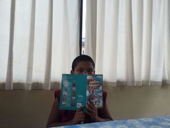 Portrait of man sitting on bed at home