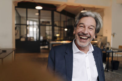 Portait of laughing senior businessman in office