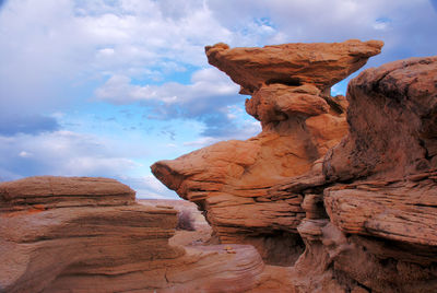 Rock formations against cloudy sky