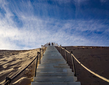 People on staircase against sky