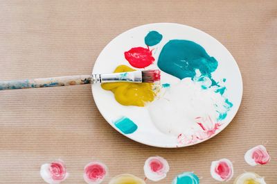 High angle view of watercolor paint palette with paintbrush on table