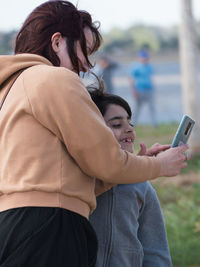 Side view of woman holding mobile phone