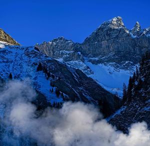 Scenic view of snowcapped mountains against clear blue sky