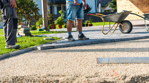 Low section of mason workers making footpath