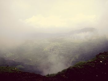 Scenic view of mountains against sky during foggy weather