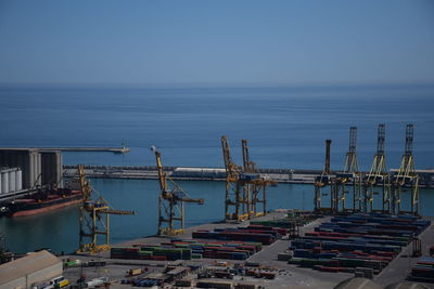 Boats at harbor against clear sky