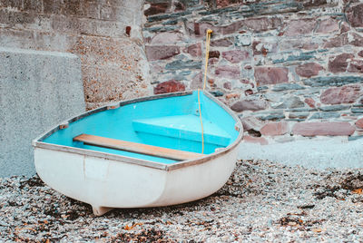 Abandoned boat moored on wall