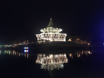 Illuminated building against clear sky at night