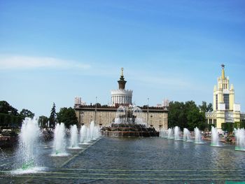 Fountain in front of building against sky