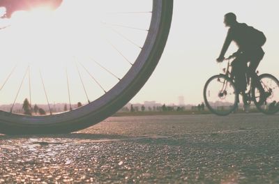 Man riding bicycle on road against sky