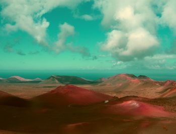 View of desert against cloudy sky