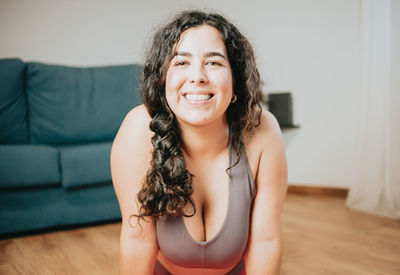 Portrait of young woman sitting on sofa at home