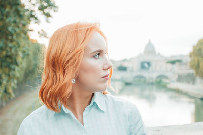 Profile view of woman standing by lake against sky