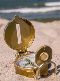 Close-up of compass in sand