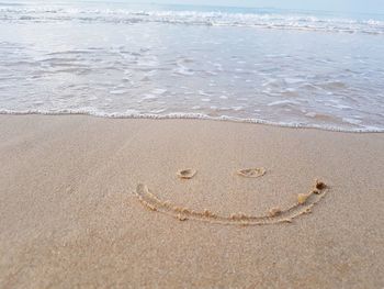 Drawing a smiley face on snady beach