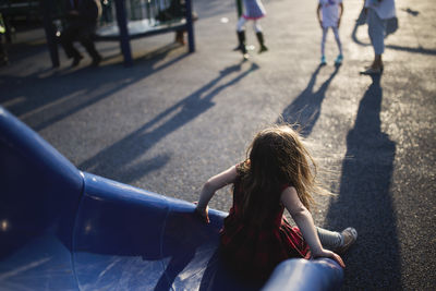 Rear view of girl playing on slide