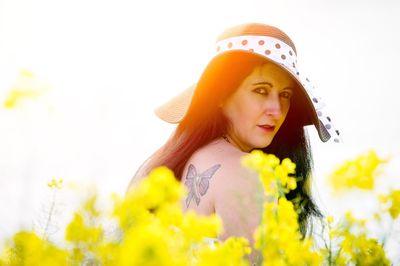 Portrait of beautiful young woman with yellow flower