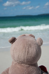 Close-up of child on beach against sky