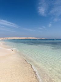 Scenic view of beach against blue sky