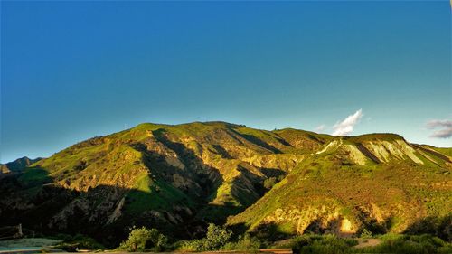 Low angle view of mountain against clear blue sky