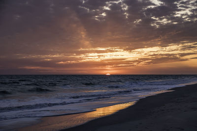 Scenic view of beach against sky during sunset