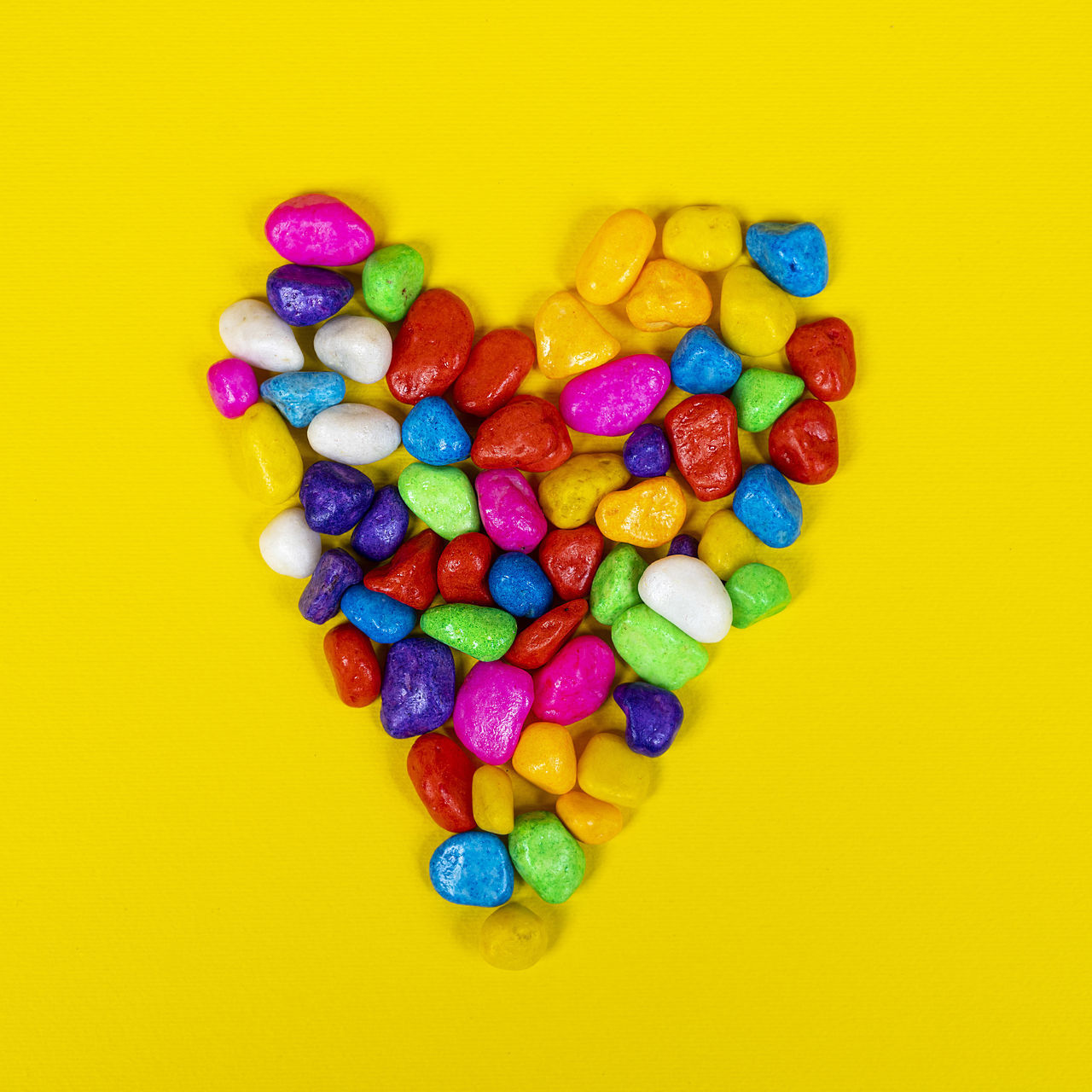 multi colored, large group of objects, colored background, studio shot, yellow background, yellow, indoors, heart shape, abundance, candy, variation, food, sweet food, pill, bead, no people, love, sweet, medicine, vibrant color, directly above, food and drink, still life, capsule, healthcare and medicine, heart, dose, blue, close-up, positive emotion, high angle view, petal